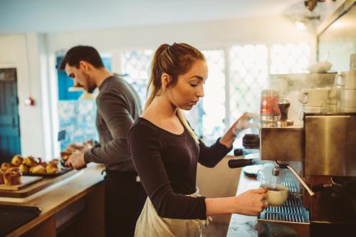 a man and woman in a kitchen preparing food at Saltmarsh Farmhouse in West Dean