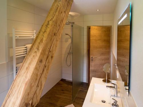 ein Badezimmer mit einer großen Holzstange in der Dusche in der Unterkunft Martinhansenhof in Oberwolfach