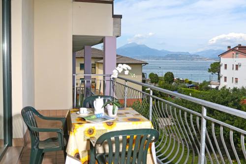 a table on a balcony with a view of the water at Nettuno Residence Hotel in Peschiera del Garda