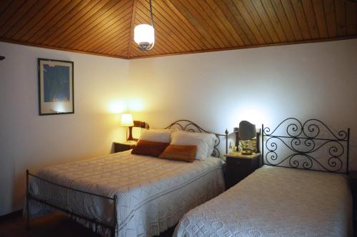 a bedroom with two beds and two lamps at Casa Do Carvalho in Viatodos