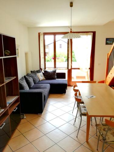 a living room with a couch and a table at Appartamento Orchidea Garda in Garda