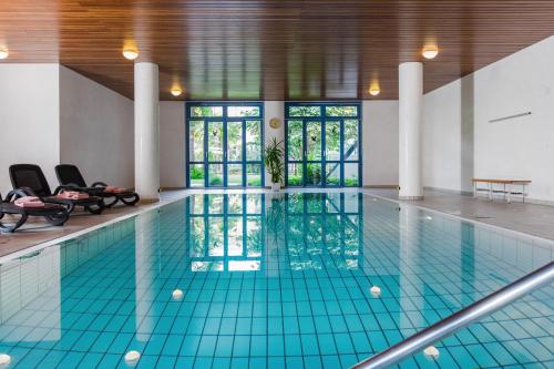 a swimming pool with blue tiles in a building at Tertianum Residenza Al Lido - Appartements & Restaurant in Locarno