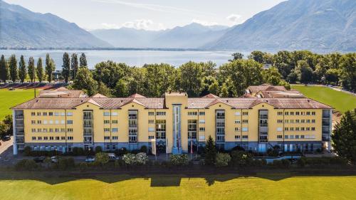an aerial view of a building with a lake and mountains at Tertianum Residenza Al Lido - Appartements & Restaurant in Locarno