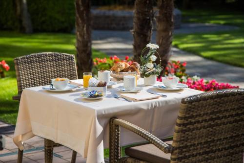 a table with a white table cloth and a basket of food at Tertianum Residenza Al Lido - Appartements & Restaurant in Locarno
