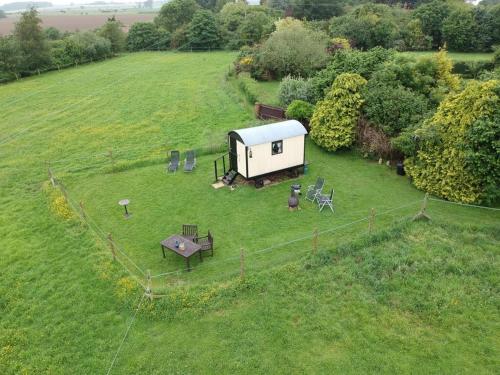 an aerial view of a small house in a field at Bells Meadow Shepherds Hut in Kings Lynn