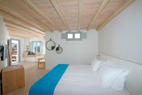 a bedroom with a bed and a wooden ceiling at Legacy Suites in Mýkonos City