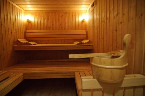 een houten sauna met een bad en een wastafel bij Residence Labellemontagne Le Village in Notre-Dame-de-Bellecombe