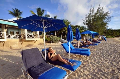 a row of blue beach chairs and umbrellas on a beach at Coconut Grove 8 Luxury Villa by Island Villas in Saint James