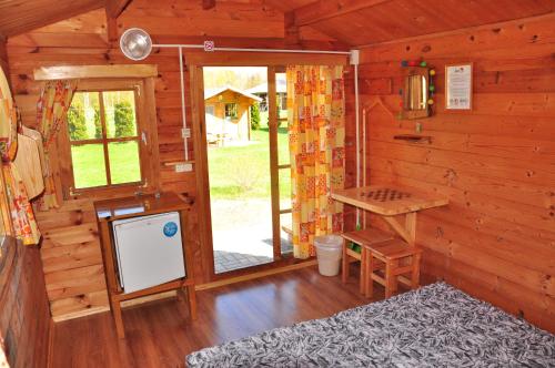 um chalé de madeira com uma cozinha e uma mesa em Campsite Leiputrija em Adazi