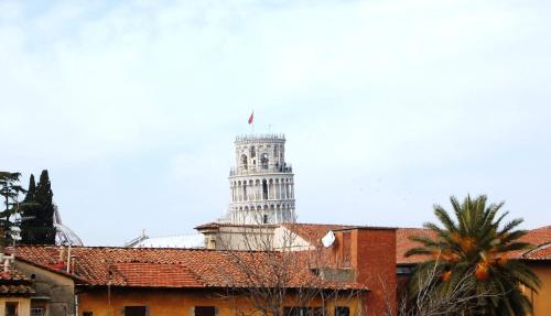 a building with a clock tower in the background at B&B Antica Piazza dei Miracoli in Pisa