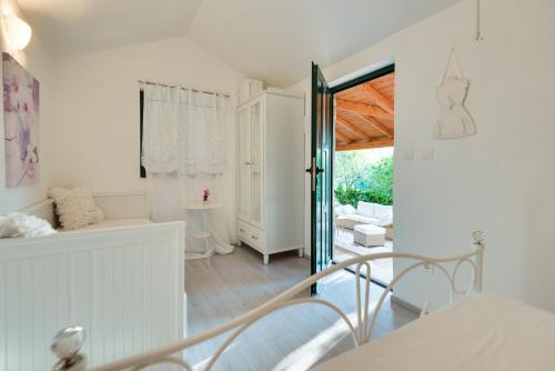 a white room with a bed and a glass door at Sun gardens in Šibenik