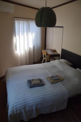 a bedroom with a bed with two towels on it at Keramiek Arita in Arita