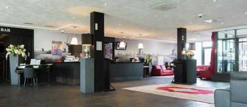a lobby with a bar with red furniture in a building at Best Western Plus Amsterdam Airport Hotel in Hoofddorp