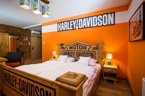 a bedroom with a bed with an orange wall at Retro hotel Garage in Ostrava