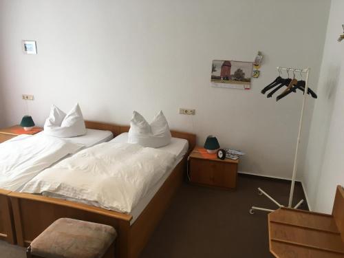 two twin beds in a room with two tables at Landhaus Pension Lützen-Stadt in Lützen