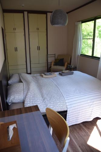 a bedroom with a large bed and a table at Keramiek Arita in Arita