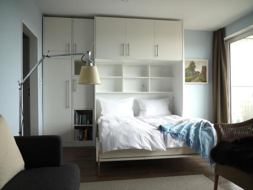 a bedroom with a bed with white cabinets at Leuchtturmblick in Wangerooge