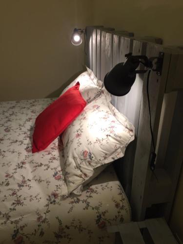 a bed with four pillows on it with a lamp at Casa do Almance in São João