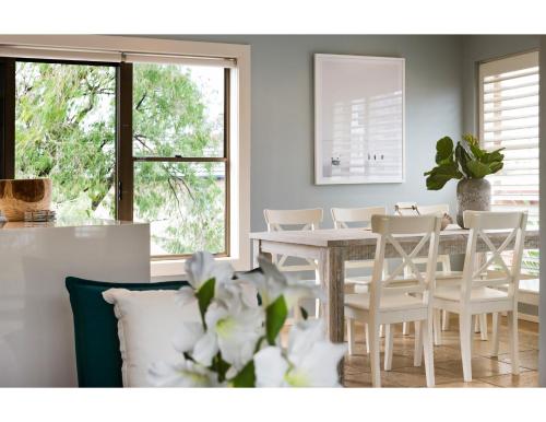 a dining room with a white table and chairs at Beachside Getaway in Freshie w Parking in Freshwater