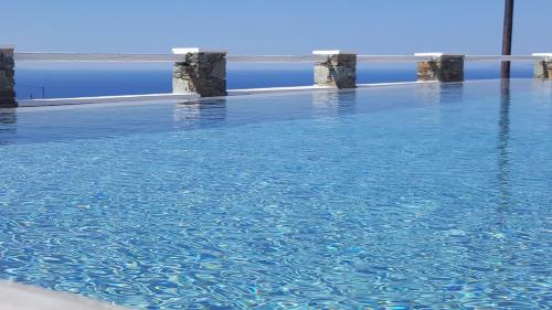 a large pool of blue water with pillars in it at Lemon Tree Houses in Áno Meriá