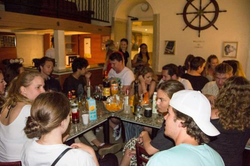 a group of people sitting around a table in a restaurant at Baccarat Hostel in Nice