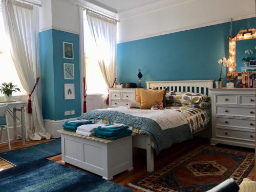 um quarto com uma cama e uma parede azul em Sidney Grove B&B em Newcastle upon Tyne