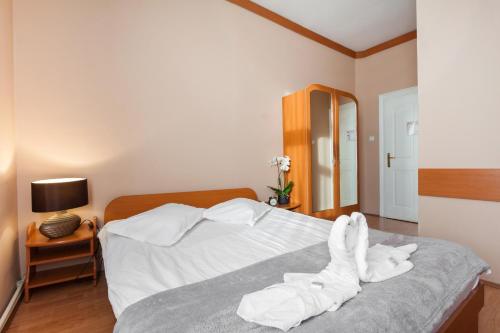 a bedroom with a bed with white towels on it at Szilagyi Hotel&Restaurant in Gheorgheni