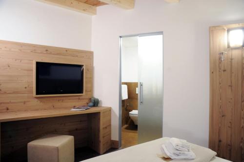 a bedroom with a tv on a wall at TOURING HOTEL & SPA in Edolo