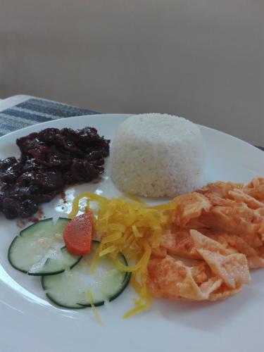 a white plate of food with rice and vegetables at Sulit Budget Hotel near Dgte Airport Citimall in Dumaguete