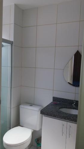 a white bathroom with a toilet and a sink at Condominio Port. da cidade Aracaju in Aracaju