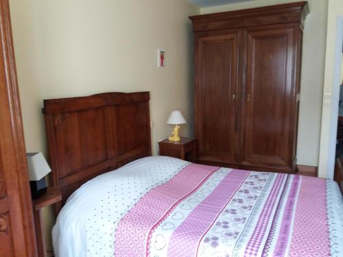 - une chambre avec un grand lit et une armoire en bois dans l'établissement Forestier, à Marennes