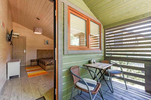 ein kleiner Raum mit einem Tisch und Stühlen auf einer Veranda in der Unterkunft Laimingas Uodas in Šventoji