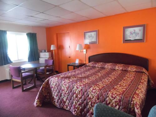 Habitación de hotel con cama y mesa en Tazewell Motel, en Tazewell