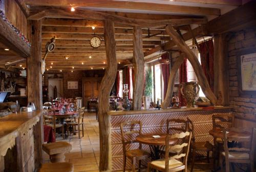 un restaurant avec des tables et des chaises et une horloge sur le mur dans l'établissement Le Relais de l'Abbaye, à Tournus