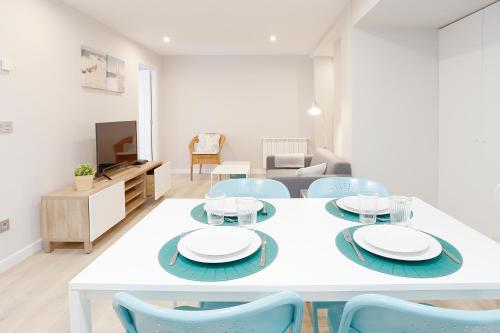 una mesa blanca y sillas en la sala de estar. en Apartamento Centro-Nautico, en Gijón