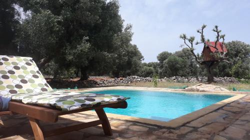 a chair sitting next to a swimming pool at Sol Invictus Est in Serranova