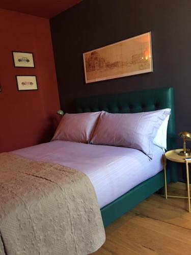 un letto con testiera verde in una camera da letto di Oriental Coast Varenna a Perledo