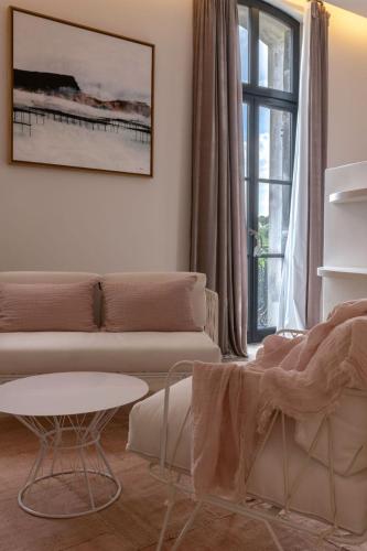 a living room with a couch and a table and a window at Domaine Tarbouriech, Demeure & Spa in Marseillan
