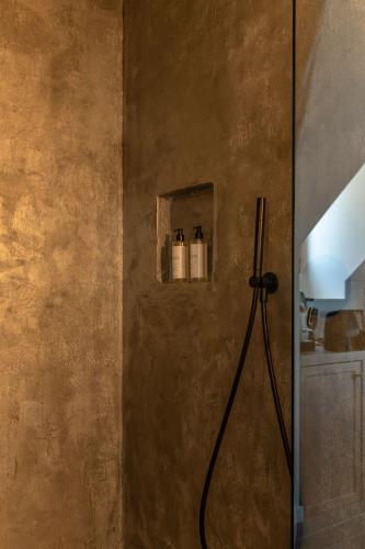 a bathroom with a shower with a hose on the wall at Domaine Tarbouriech, Demeure & Spa in Marseillan