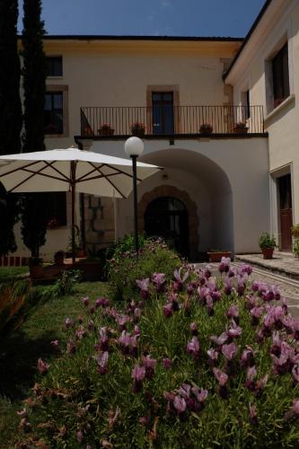 an umbrella and flowers in front of a building at Hostel il Tetto in Melfi