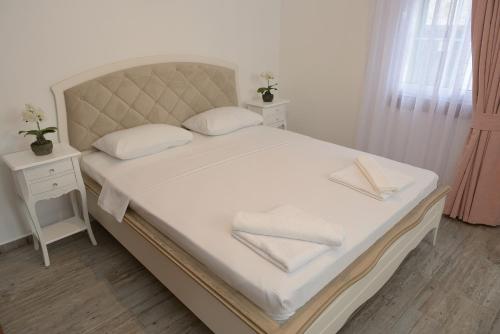 a white bed with two white towels on it at Brothers Cesme Hotel in Cesme