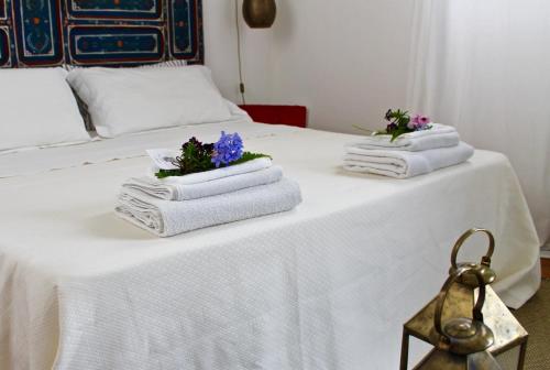 a white table with towels and flowers on it at Buon Consiglio B&B in Lecce