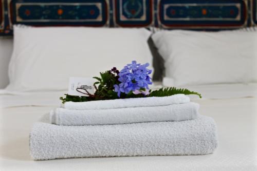 a pile of towels with purple flowers on a table at Buon Consiglio B&B in Lecce