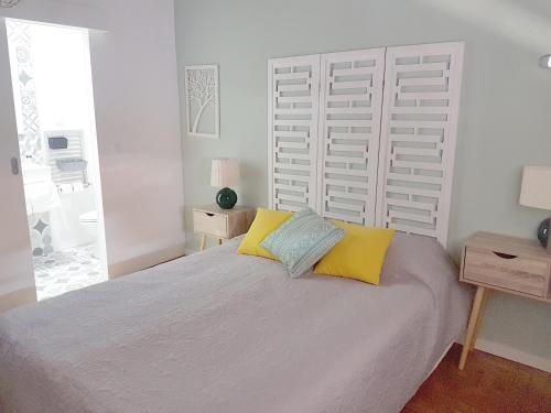a bedroom with a large bed with yellow and blue pillows at Casa70 in Setúbal