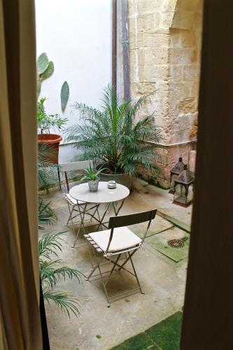 a patio with a table and chairs and plants at Buon Consiglio B&B in Lecce
