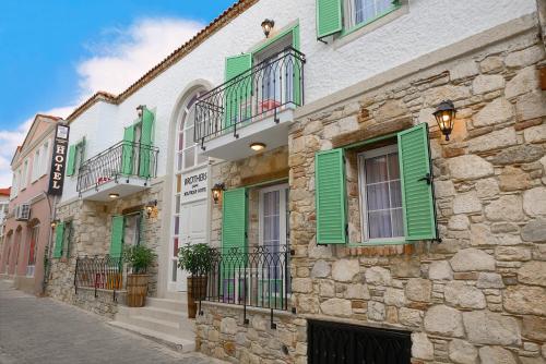 a group of buildings with green shutters on them at Brothers Cesme Hotel in Cesme