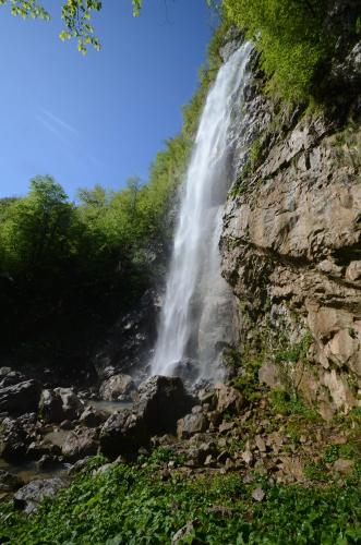 a waterfall on the side of a cliff at Apartma Fani-Kobarid in Podbela