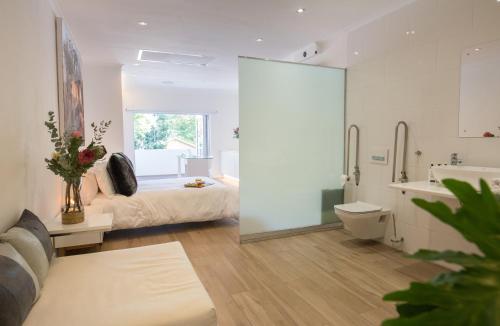 a bedroom with a bed and a bathroom with a sink at theLAB Franschhoek in Franschhoek