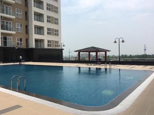 下龍灣的住宿－Hometel Newlife Hạ long，一座大型游泳池,其凉亭位于大楼旁