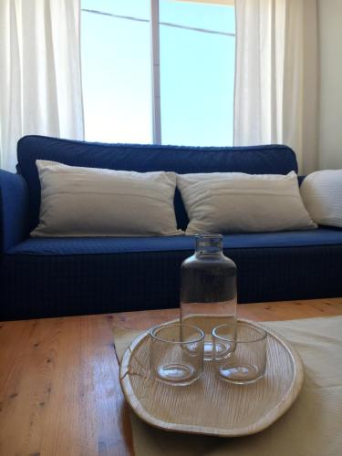 two glasses on a plate on a table with a blue couch at Casa Algaida in Sanlúcar de Barrameda